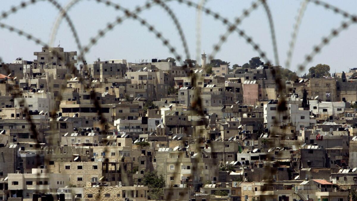 The Palestinian refugee camp of Kalandia is seen through razor wire near the West Bank city of Ramallah on June 4, 2007.