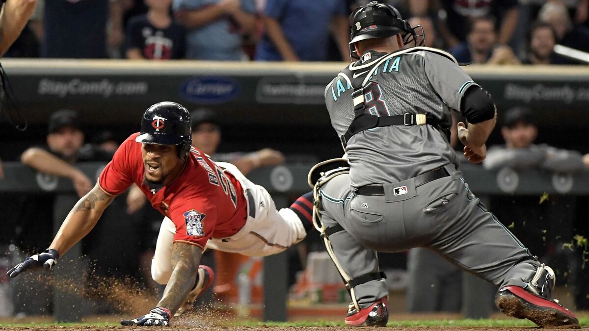 Twins center fielder Byron Buxton slides safely into home plate with an inside-the-park home run as Diamondbacks catcher Chris Iannetta fields a late relay throw during the fourth inning Friday.