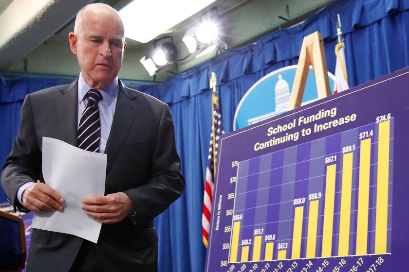FILE - In this May 11, 2017, file photo, California Gov. Jerry Brown walks past a chart showing the increase in education spending in his proposed 2017-2018 state budget as he leaves a news conference in Sacramento, Calif., where he released his revised spending plan. Gov. Brown signed the $125 billion state budget on Tuesday, June 27, 2017, that increases funding for education and social services. The budget takes effect July 1. (AP Photo/Rich Pedroncelli, File)