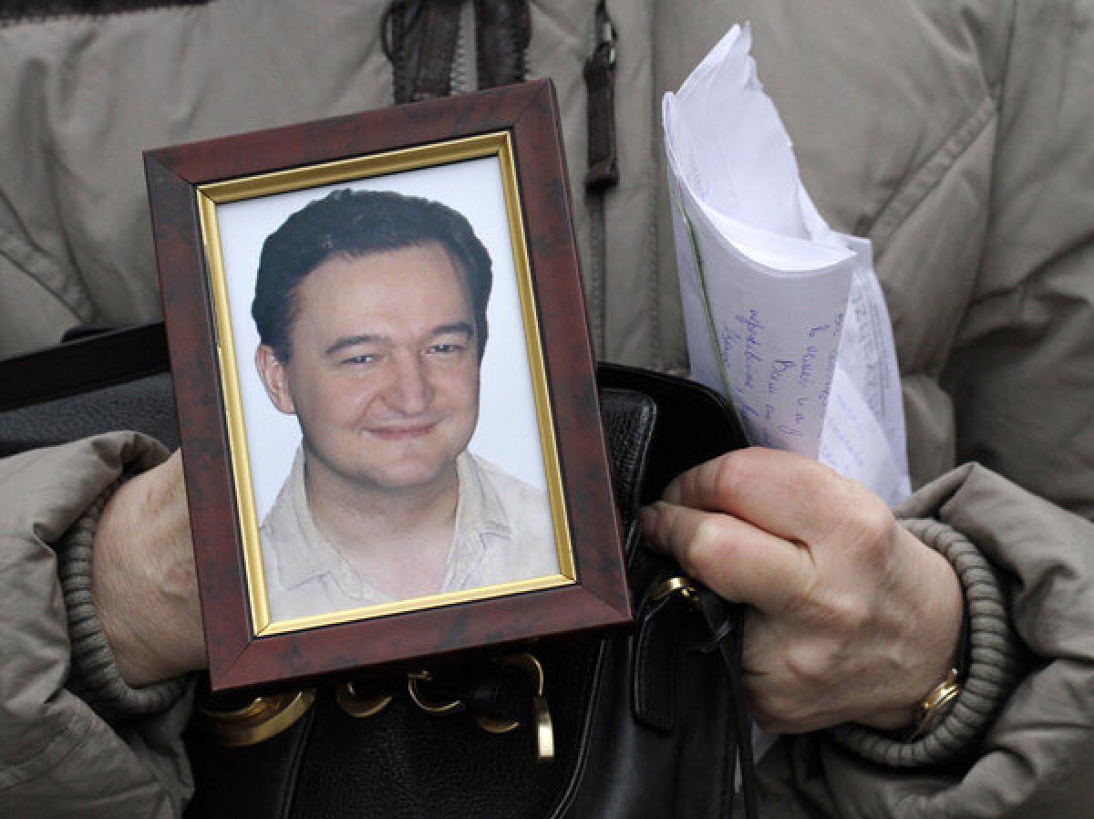 In a file photograph from 2009, Nataliya Magnitskaya holds a photo of her son, Russian lawyer Sergei Magnitsky, who died in custody that year. The U.S. has named 18 Russians to be penalized for alleged human rights abuses under a law named for Magnitsky.