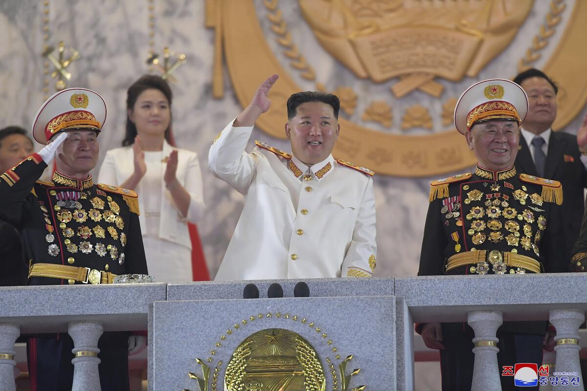 North Korean leader Kim Jong Un waves from an elaborate stage.