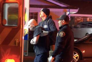 First responders help an individual into a waiting ambulance in the 6600 block of Dillman Street in Lakewood on April 7.