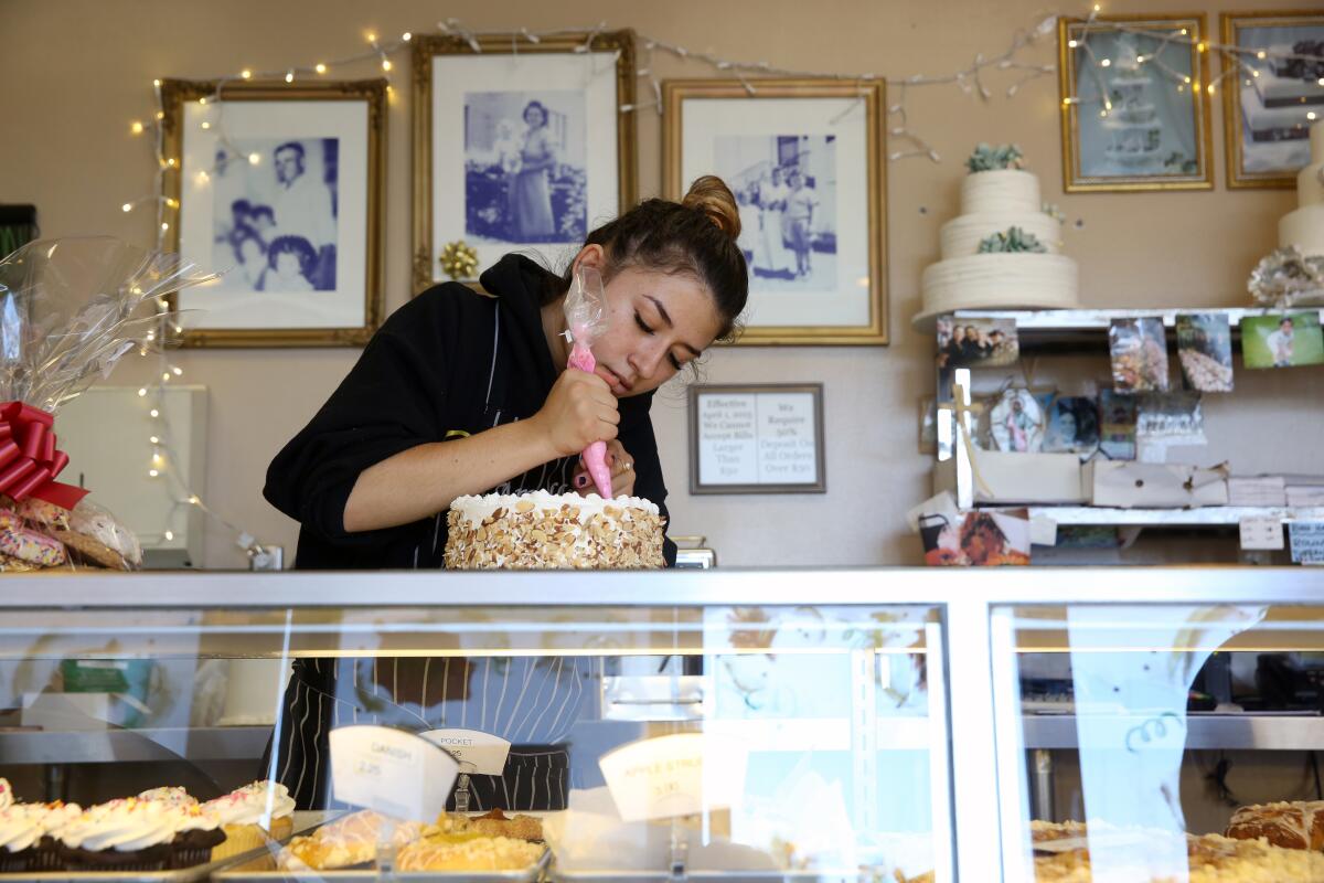 How about a custom cake? Mikayla Gazeley decorates a cake for a customer at Amalfitano Bakery.