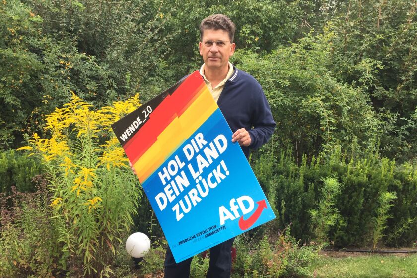 Joerg Quitt, a German engineer, who supports the far-right Alternative for Germany (AfD) party in Brandenburg state. He is holding an AfD campaign poster that reads “Take your country back."