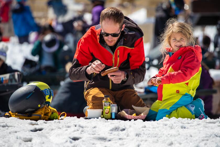 BIG BEAR, CA - MARCH 25: Steve Marion, 38, left, with 4-year-old daughter Piper Mormon sits down for lunch on a sunny day at Big Bear Mountain Resort on Saturday, March 25, 2023 in Big Bear, CA. (Irfan Khan / Los Angeles Times)