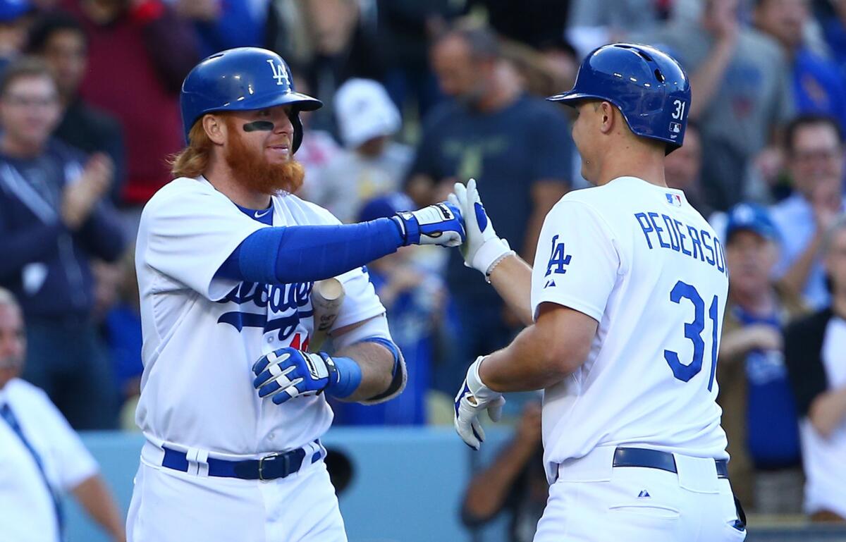 Joc Pederson high-fives teammate Justin Turner after Pederson hit a solo home run Wednesday.