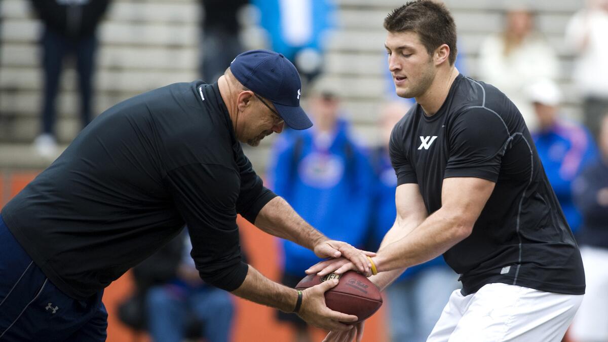 Noel Mazzone works with quarterback Tim Tebow during a workout for NFL scouts on March 17, 2010.