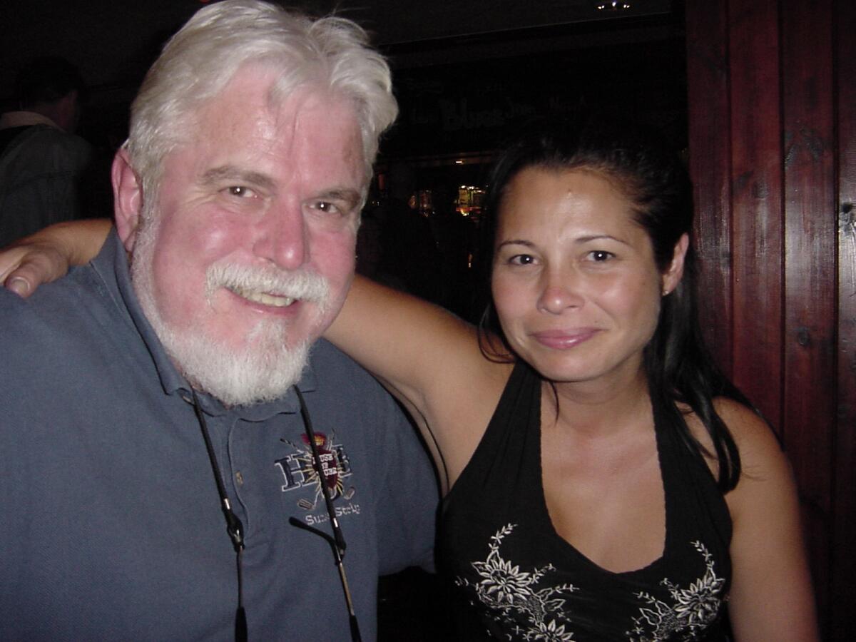 A father and his daughter, with her arm around him. 