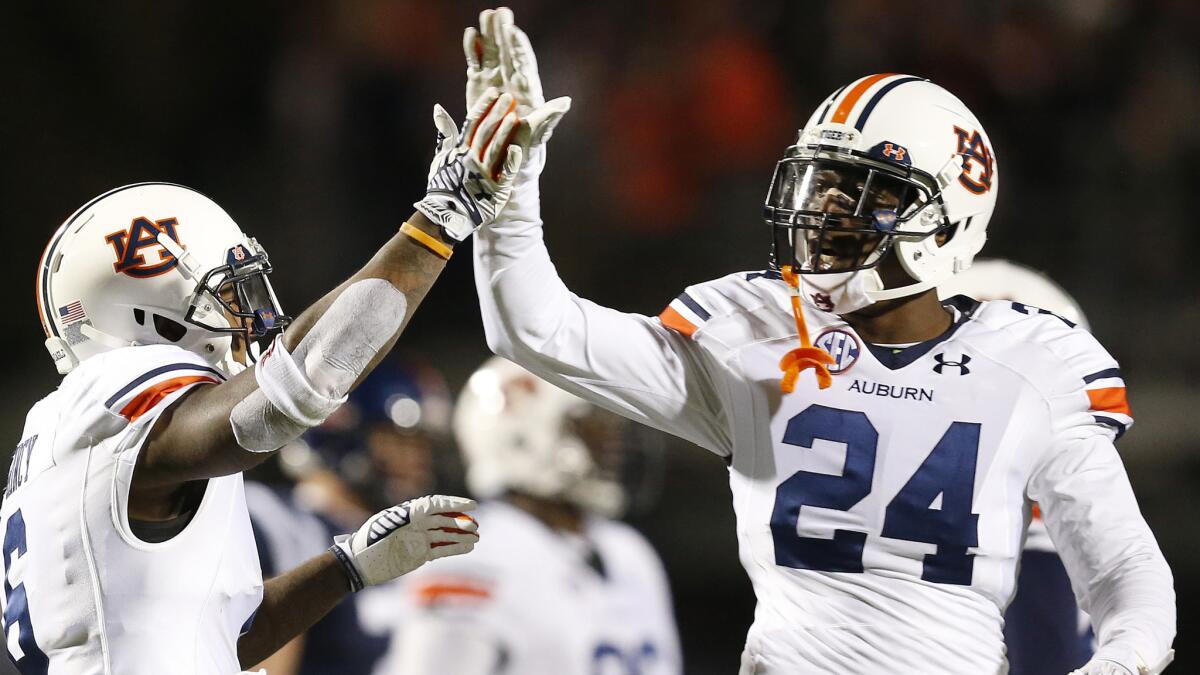 Auburn's Jonathon Mincy, left, celebrates with teammate Derrick Moncrief after scoring a touchdown during a 35-31 win over Mississippi on Saturday.