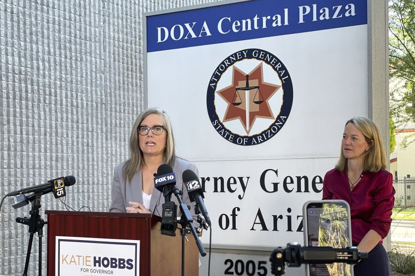 Arizona Secretary of State Latie Hobbs, left, the Democratic nominee for governor, and Kris Mayes, a Democrat running for attorney general, speak to reporters outside the Arizona Attorney General's Office in Phoenix on Saturday, Sept. 24, 2022. (AP Photo/Jonathan J. Cooper)