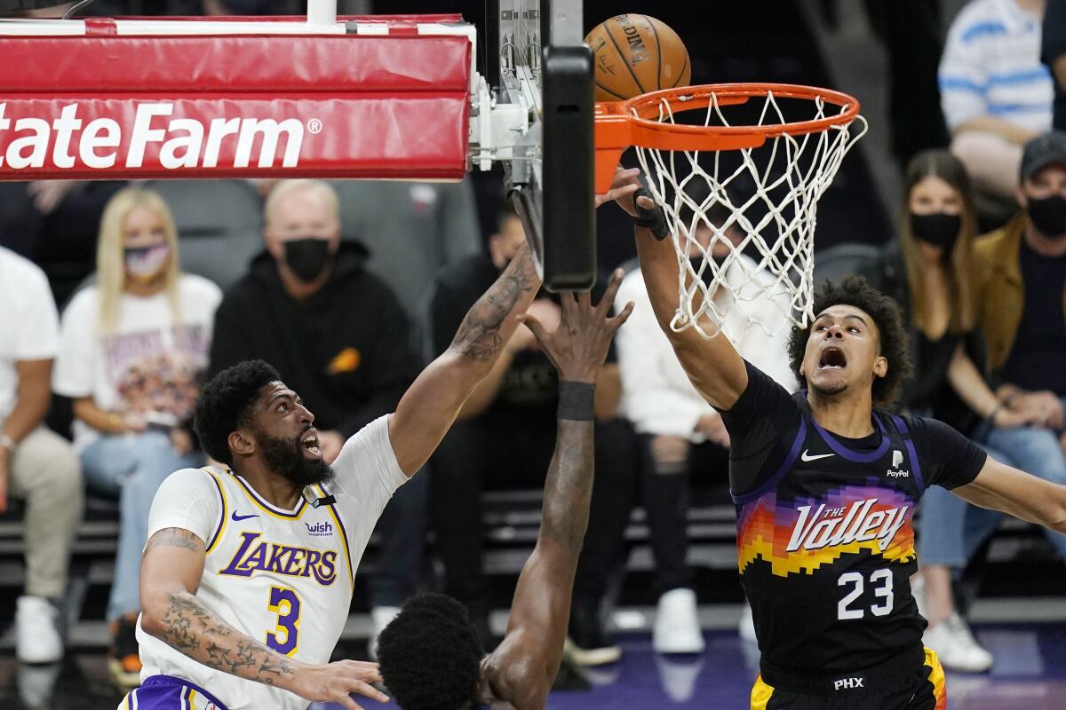 Phoenix Suns forward Cameron Johnson, right, deflects a shot by Lakers forward Anthony Davis during the first half of Game 1.