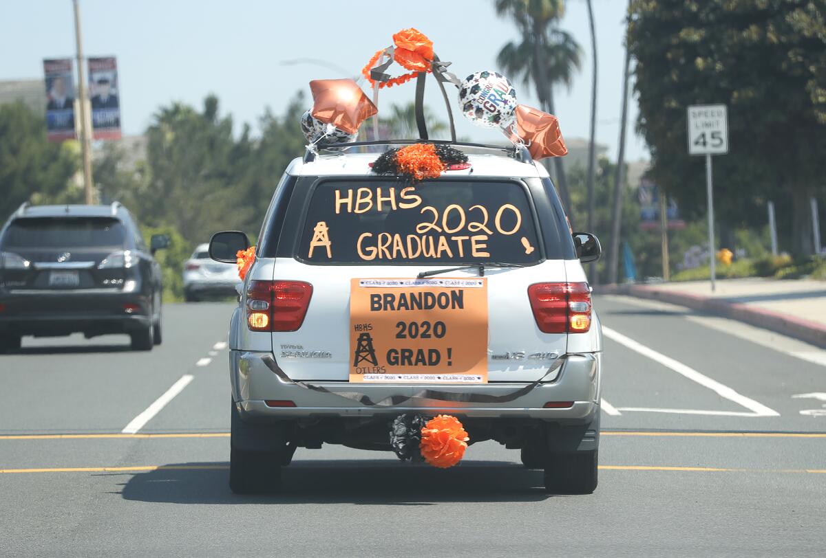 Brandon Ferrin drives to Huntington Beach High School for a drive-through graduation on Wednesday.