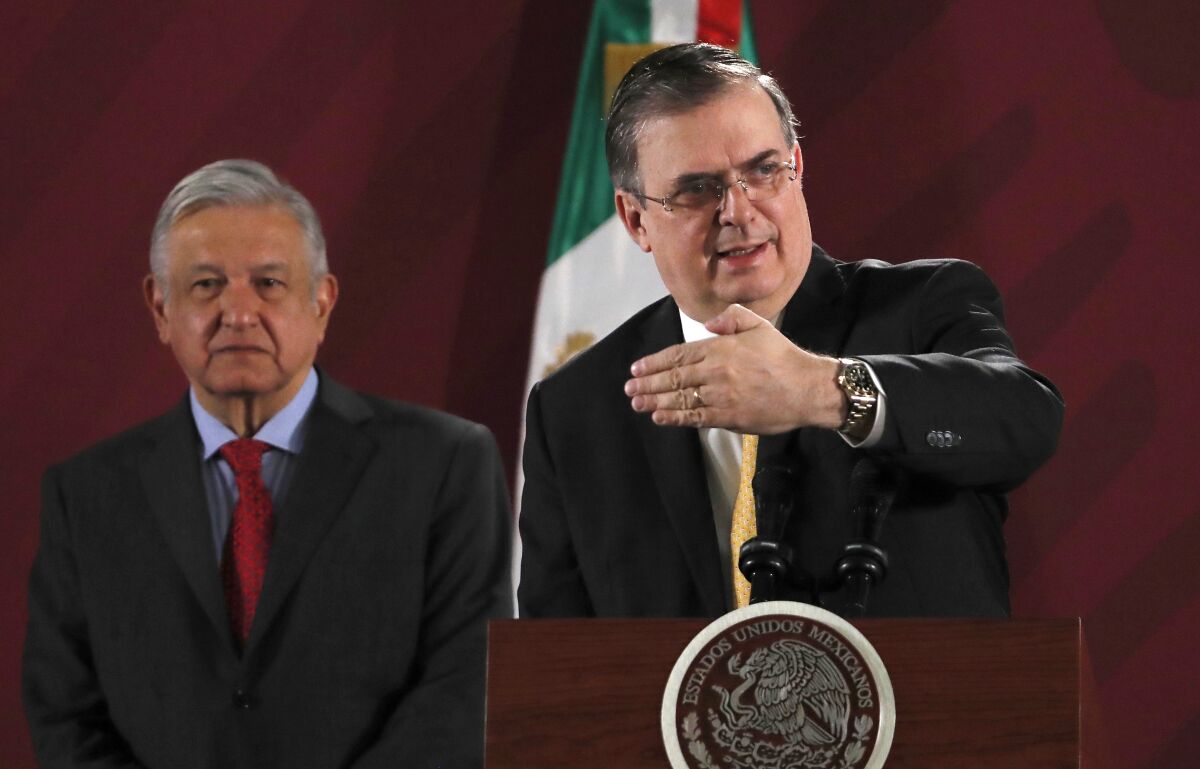 FILE - In this Nov. 12, 2019 file photo, Mexican Foreign Minister Marcelo Ebrard answers questions from the press as President Andres Manuel Lopez Obrador stands behind during the president's daily morning press conference at the National Palace, in Mexico City. A gathering of leaders from Latin America and the Caribbean in Mexico City on Saturday, Sept. 17, 2021, is the latest sign of Mexico flexing its diplomatic muscle as it looks to assert itself as the new mediator between the region and the United States. (AP Photo/Marco Ugarte, File)