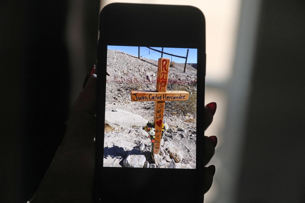 A picture of a wooden cross is shown on a cellphone.