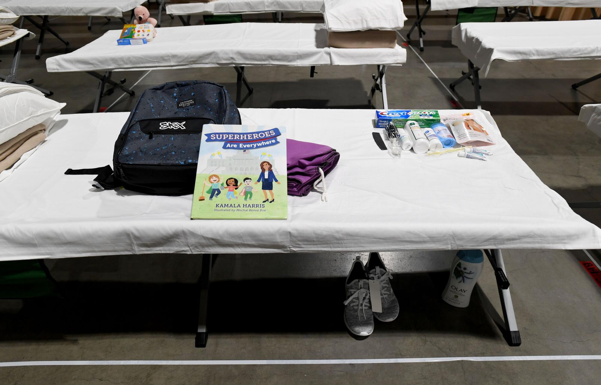 A backup, book and toiletries sit on a cot