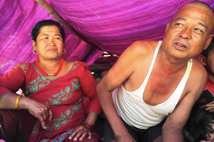 Nani Tamang, left, and husband Mangale live in a hut near where their village once stood in Jure, Nepal. A landslide wiped out the town in August, and the Tamangs are still awaiting aid from the government.