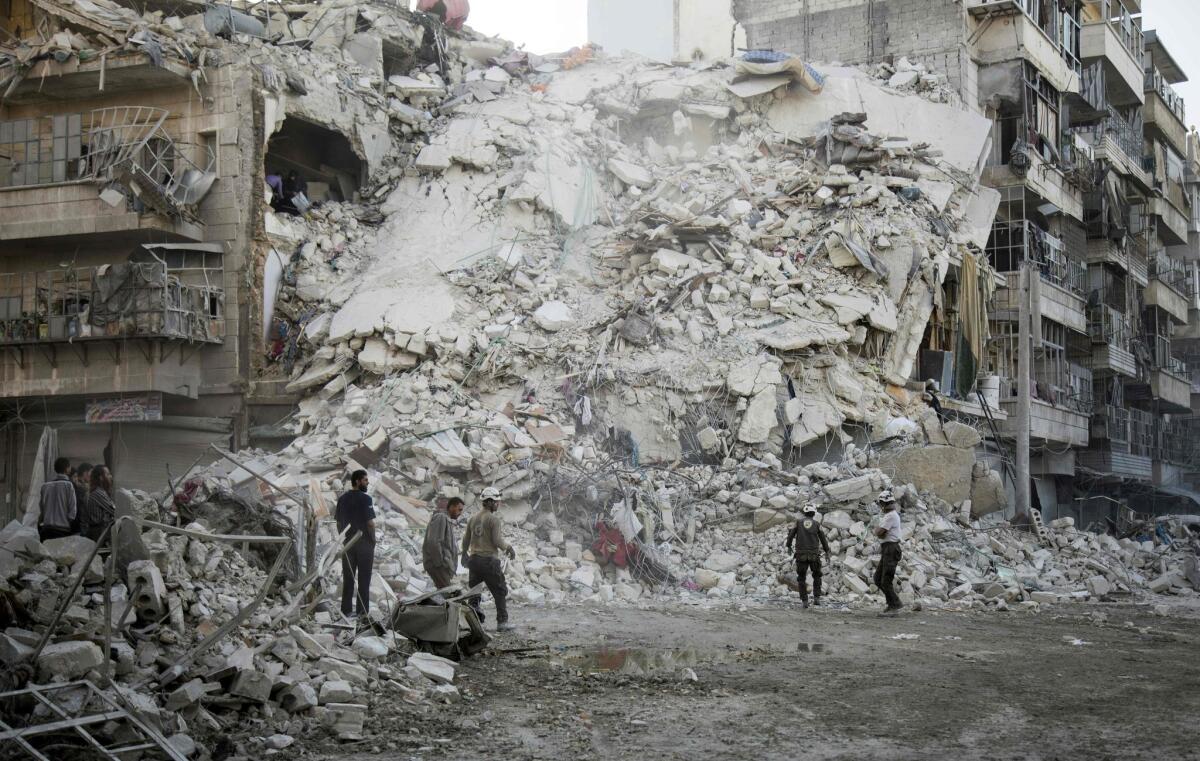 Members of the Syrian civil defense volunteers, known as the White Helmets, search for victims amid the rubble of a destroyed building after airstrikes in the rebel-held Qatarji neighborhood of Aleppo on Monday.