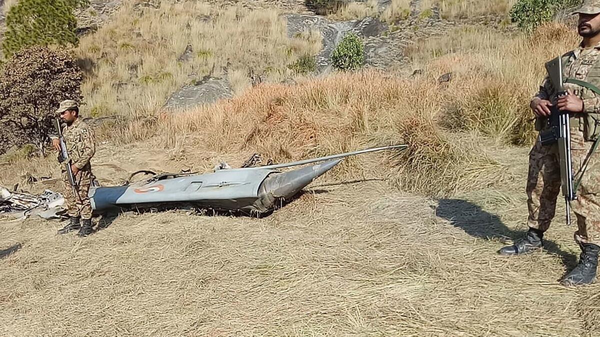Pakistani soldiers stand next to what Pakistan says is the wreckage of an Indian fighter jet shot down Wednesday in Kashmir.