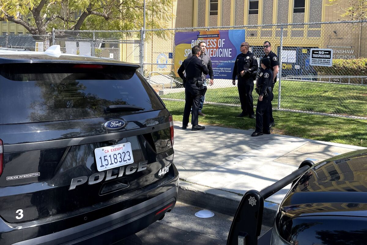 Police officers stand in front of a school