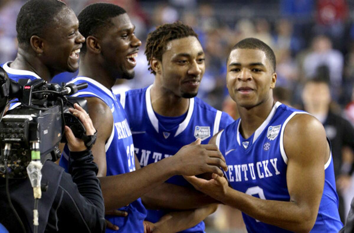 Kentucky guard Aaron Harrison, right, is congratulated by teammates (from left) Julius Randle, Alex Poythress and James Young after making the game-winning shot against Wisconsin on Saturday night.