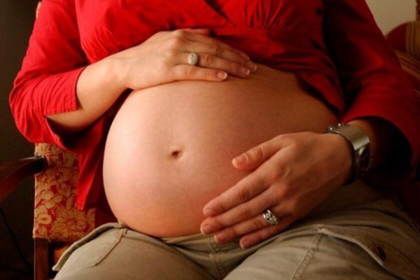 A pregnant woman shows off her stomach; an ambitious study looked for links between abnormalities in the placenta and autism spectrum disorder.