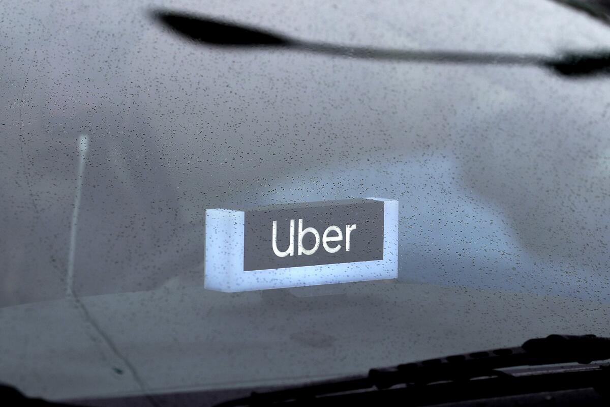 An Uber sign is displayed inside a car