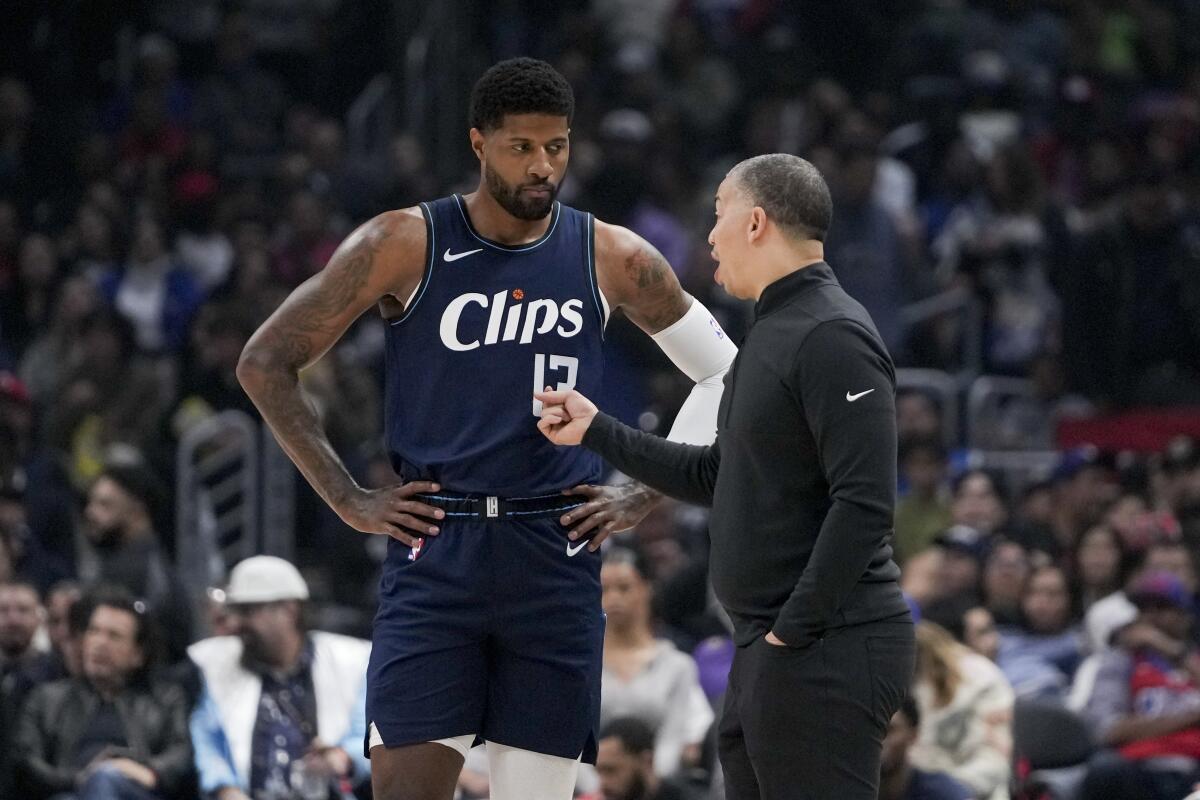 Clippers forward Paul George, left, speaks with coach Tyronn Lue during the first half Friday.