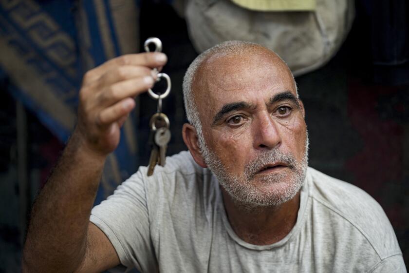 Hassan Nofal, 53, who was displaced by the Israeli bombardment of the Gaza Strip, holds the keys to his home that he was forced to leave with his family at a makeshift tent camp in Khan Younis, southern Gaza Strip, Thursday, July 4, 2024. Over nine months of war between Israel and Hamas, Palestinian families in Gaza have been uprooted repeatedly, driven back and forth across the territory to escape the fighting. Each time has meant a wrenching move to a new location and a series of crowded, temporary shelters. (AP Photo/Abdel Kareem Hana)