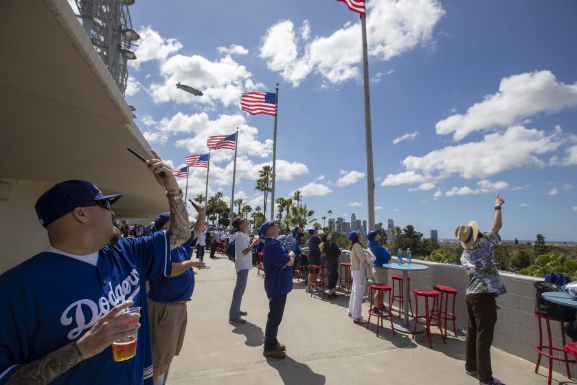 LOS ANGELES, CALIF. -- THURSDAY, MARCH 28, 2019: Dodgers fans watch the U.S. Army Golden Knights parachute into Dodger Stadium as they celebrate Opening Day with the Dodgers play the Diamondbacks at Dodger Stadium in Los Angeles, Calif., on March 28, 2019. (Allen J. Schaben / Los Angeles Times)