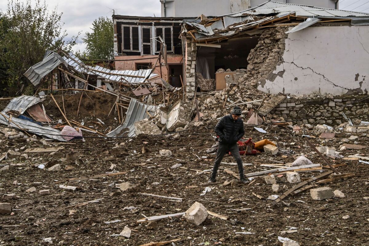 A man walks in front of a destroyed house after shelling in the breakaway Nagorno-Karabakh region's main city of Stepanakert.