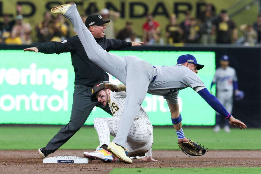 San Diego's Jackson Merrill beats Dodgers shortstop Miguel Rojas to second base during the second inning of Game 3.