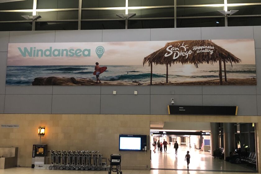 The San Diego Tourism Authority marquee in San Diego International Airport depicting Windansea beach.