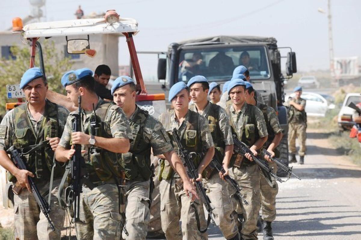 Turkish soldiers move into position in the southern border town of Akcakale, across from Tal Abyad in Syria.