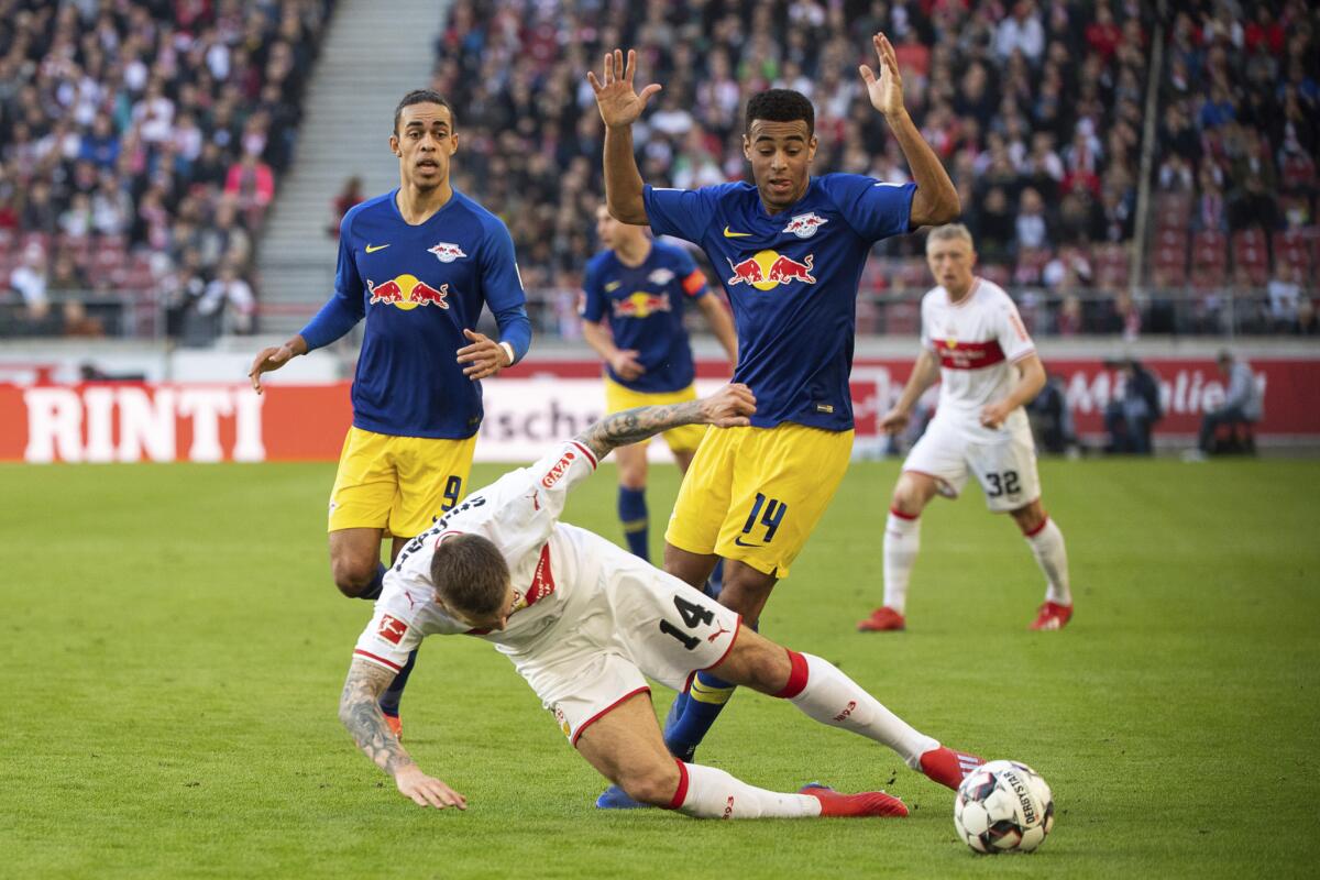 Alexander Esswein, del Stuttgart, centro izquierda, y Tyler Adams, del Leipzig, disputan un balón durante un partido de la Bundesliga en Stuttgart, sábado 16 de febrero de 2019. Leipzig ganó 3-1. (Sebastian Gollnow/dpa via AP)