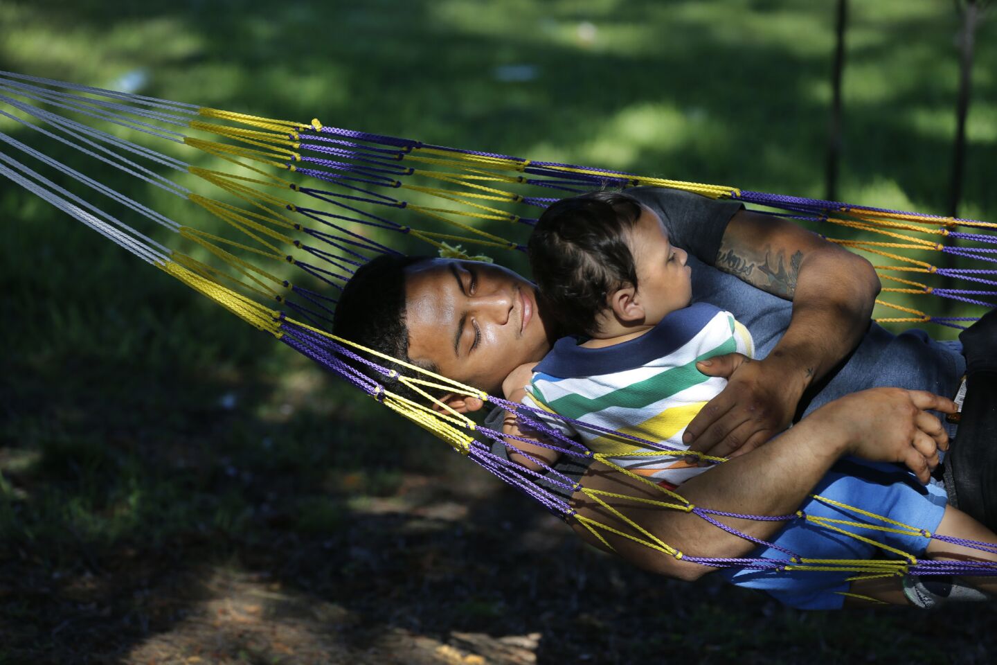 Luis Alvarez swings in a hammock with his 11-month-old son, Adrian Alvarez of Los Angeles, in the shade at Whittier Narrows Recreation Area.