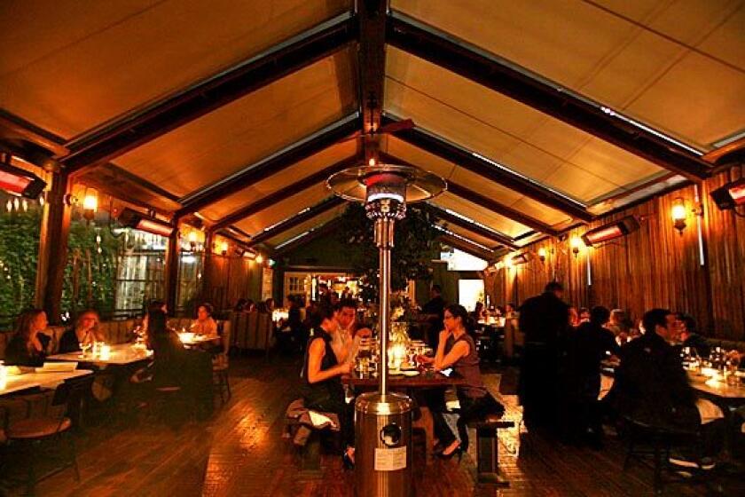 One of Eveleigh's dining rooms has a canvas roof, a communal table in the middle and open-air sides.