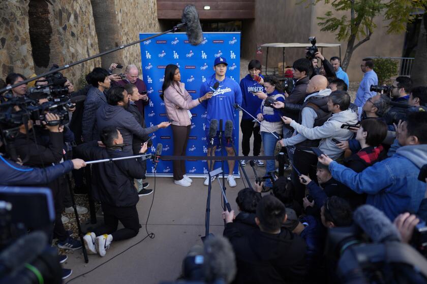Los Angeles Dodgers' Shohei Ohtani, with interpreter Ippei Mizuhara, right, speaks to media at Camelback Ranch in Phoenix, Friday, Feb. 9, 2024, on the first day of spring training baseball workouts for the Dodgers. (AP Photo/Carolyn Kaster)