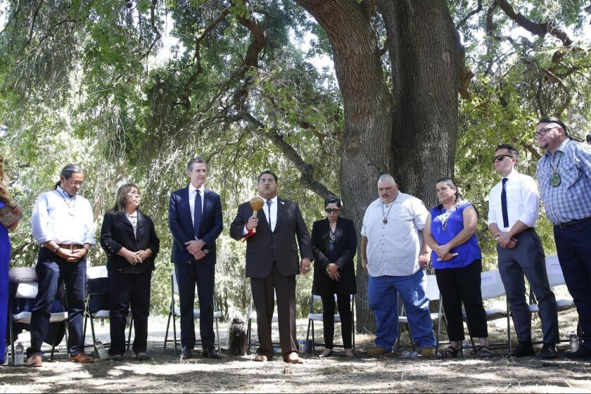 Assemblyman James Ramos, D-Highlands, of the San Manuel Band of Mission Indians, fifth from left, opens a meeting with tribal leaders from around the state, attended by Gov. Gavin Newsom, fourth from left, at the future site of the California Indian Heritage Center in West Sacramento, Calif., Tuesday, June 18, 2019. Newsom took the occasion to formally apologize to tribal leaders from around California for the violence, mistreatment and neglect inflicted on Native Americans throughout the state's history. (AP Photo/Rich Pedroncelli)