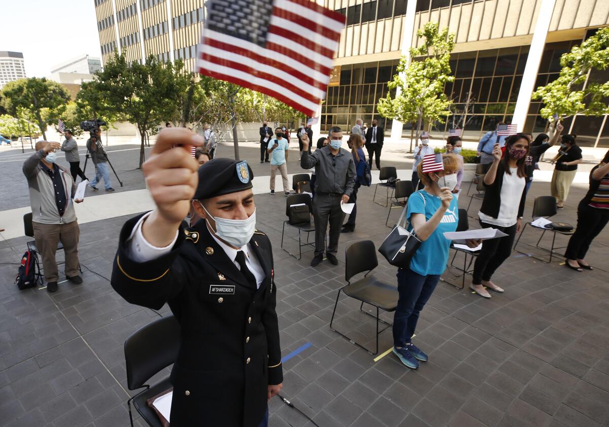 People wave the American flag after taking the oath to become U.S. citizens in Los Angeles on May 3.