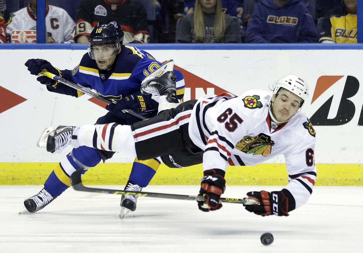 Blackhawks forward Andrew Shaw (65) is sent flying after colliding with Blues forward Scottie Upshall while reaching for a puck during the second period in Game 7.