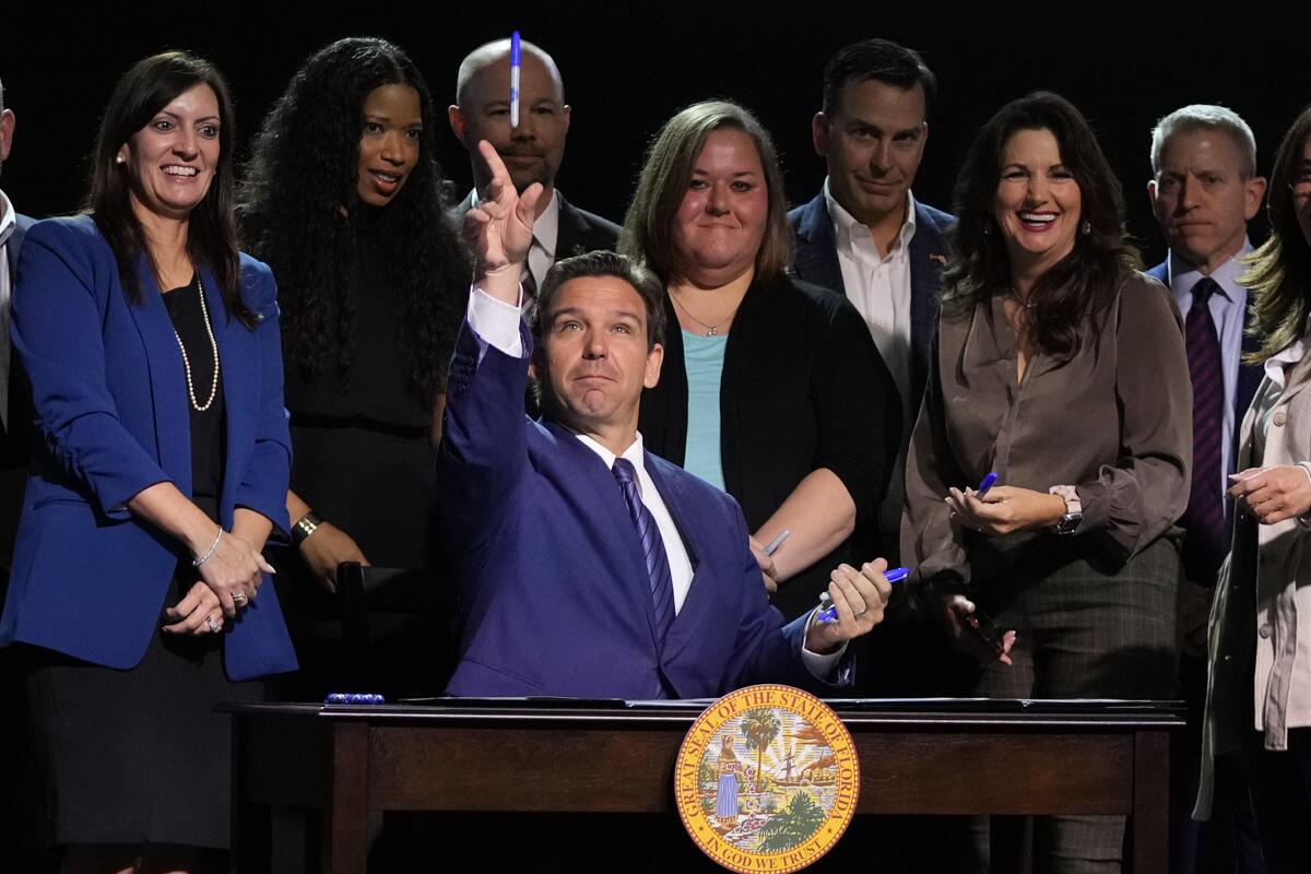 Backed by a group, Florida Gov. Ron DeSantis signs bills in a church in Lighthouse Point, Fla., in May.