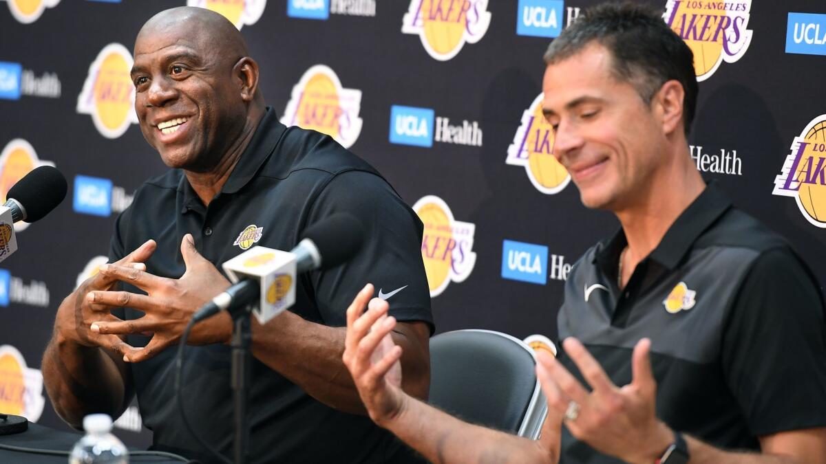 Magic Johnson, president of basketball operations, and General Manager Rob Pelinka share a laugh with reporters during a media session on Thursday at the Lakers' training facility in El Segundo.