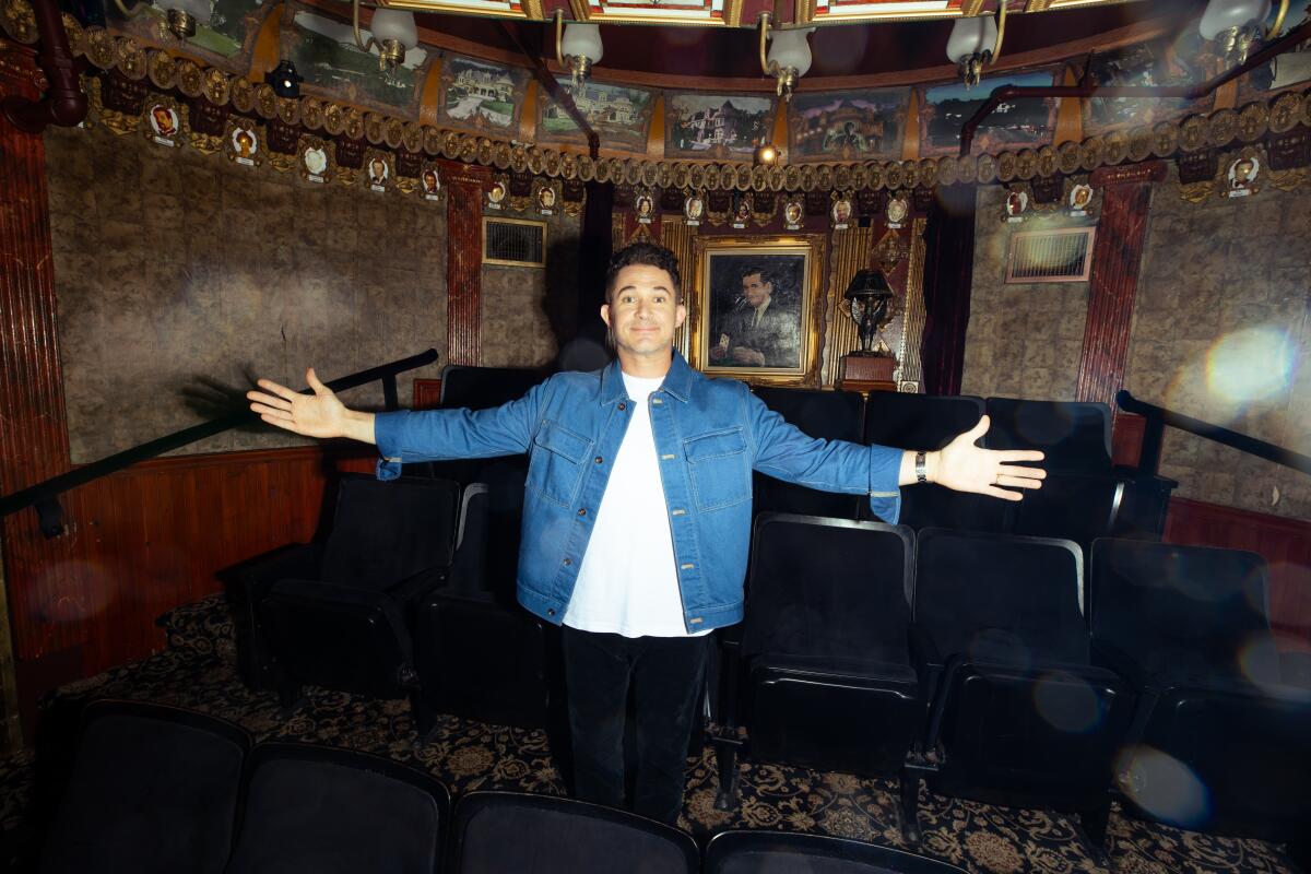 With arms held wide open, a man stands inside the Magic Castle