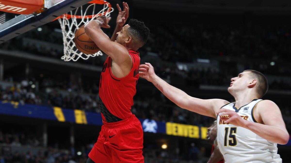 Denver Nuggets center Nikola Jokic, right, fouls Portland Trail Blazers guard CJ McCollum during the second half of Game 2 of an NBA second-round playoff series on Wednesday in Denver.