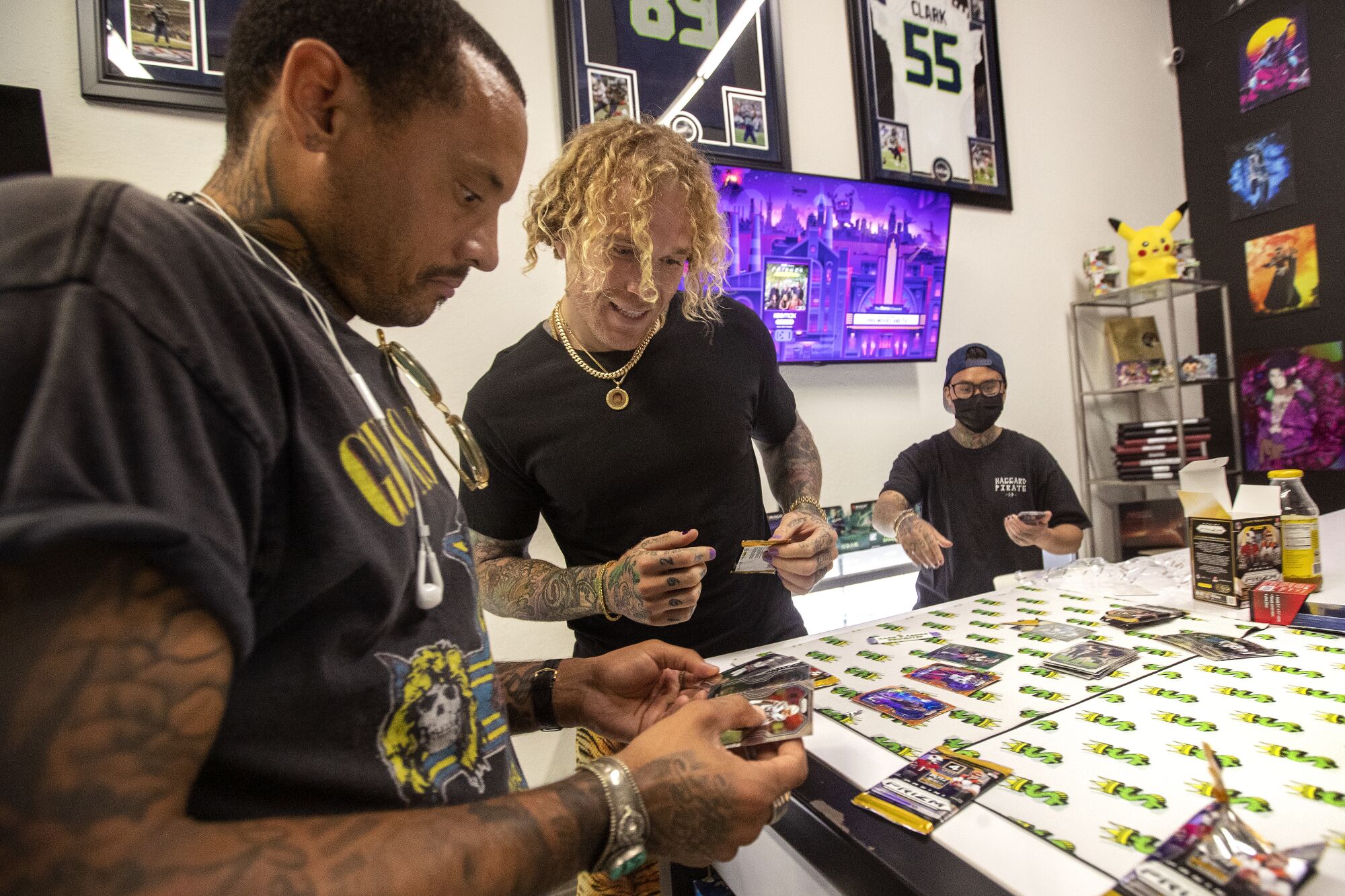 Former pro soccer player Jermaine Jones, left, shows football cards to Cassius Marsh, co-founder of Cash Cards Unlimited.