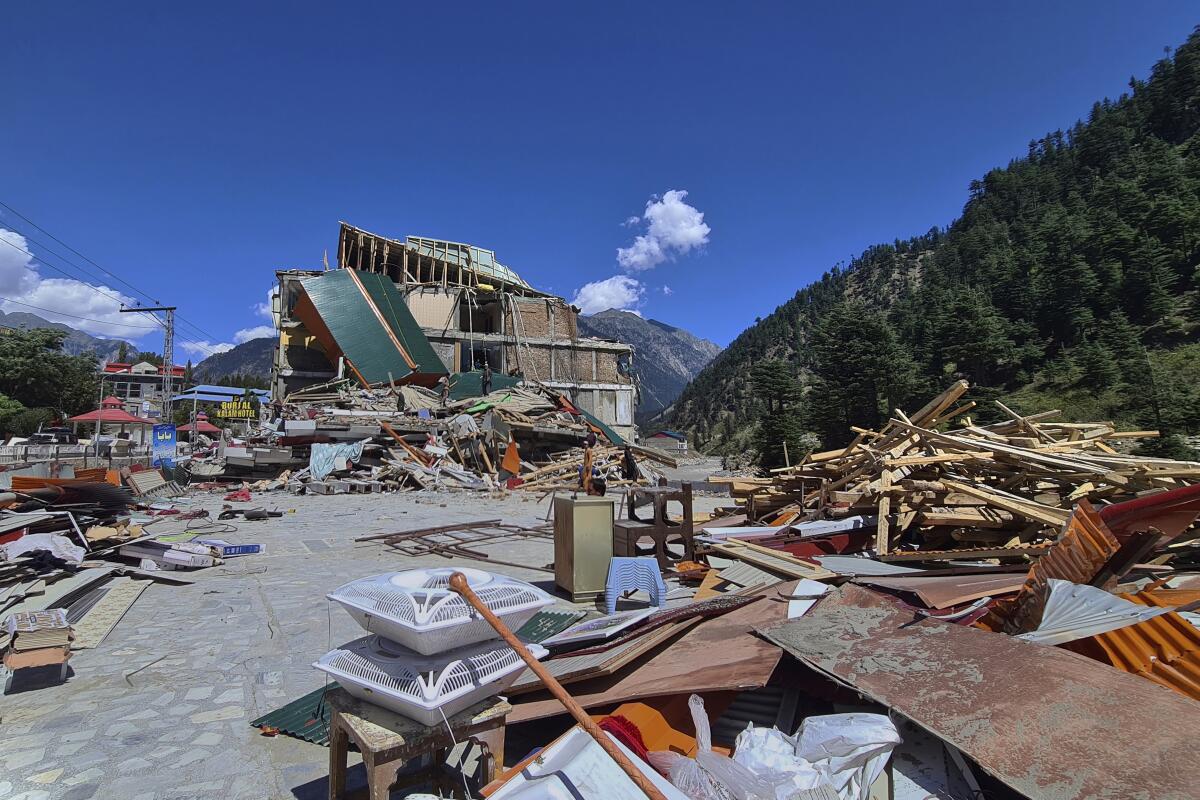 Items salvaged from a hotel damaged by floodwaters are stacked among piles of debris