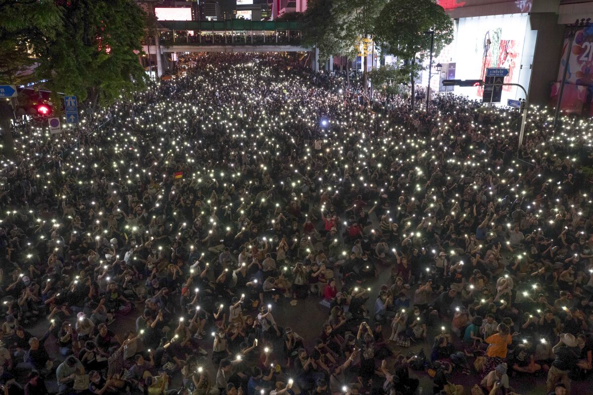 Protesters hold up flashlights in Bangkok.