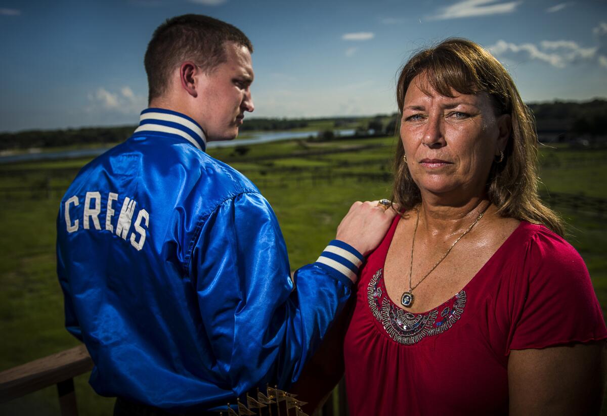 Laurie Crews, and her son Travis Crews, 23, he was two-years-old when Tim Crews was killed in a boating accident at Little Lake Nellie, in the background, in Clermont, FL., Friday, July 12, 2013. Tim Crews played on the last Dodgers team to win the World Series (Photo by Roberto Gonzalez/For The Times)