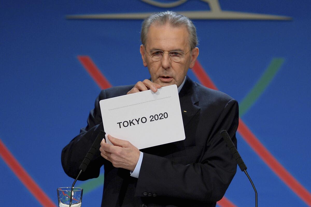 Jacques Rogge shows a card naming Tokyo as 2020 Summer Olympics host city.