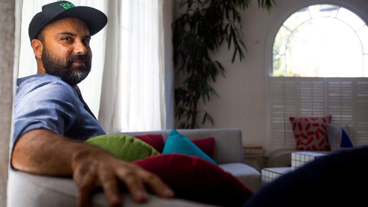 Bend Goods designer Gaurav Nanda sits on one his couches at his home and studio. (Gina Ferazzi / Los Angeles Times)